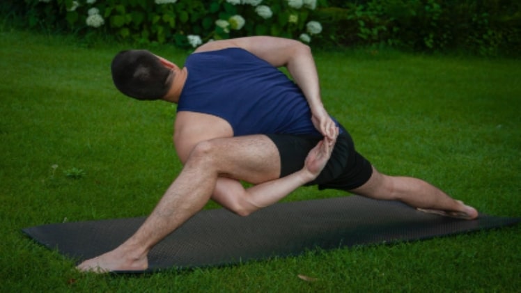 A picture of a man doing yoga in the park, showing the cost flexibility of Red Shield Administration.